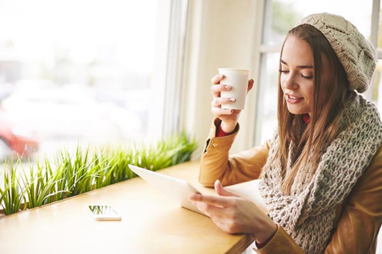 dropshipping-mode 4 Leuk meisje in warme gebreide kleding met behulp van de touchpad in café