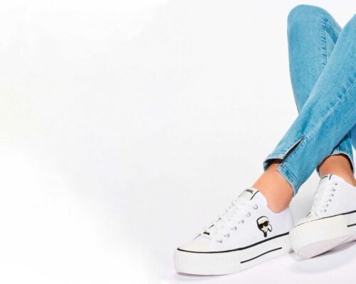 Two young stylish smiling hippie brunette and blond women. Models in summer sunny day in hipster clothes sitting on penny skateboard on the street background. Positive teenagers